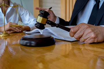 Judge gavel with Justice lawyers having team meeting at law firm background. Concepts of Law and Legal services.