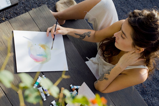 young woman making painting with watercolors