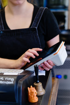 woman operating eftpos machine in a cafe