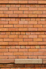 Close up view of an old reddish brown European brick wall background with unique textured facade