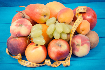 Tape measure with fresh natural fruits containing nutritious vitamins for healthy lifestyles