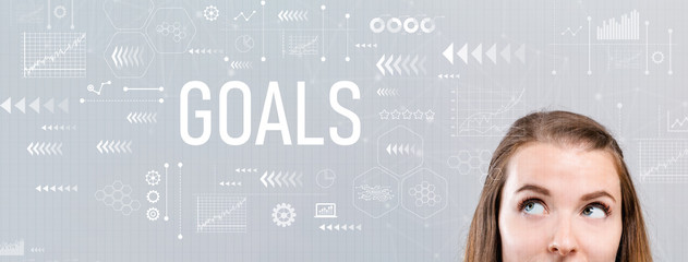 Goals with young woman looking upwards on a gray background