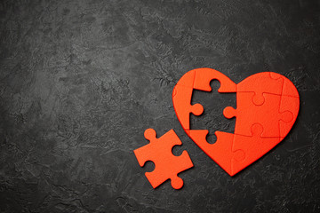 Heart puzzle red on black background. Concept second half of the heart in love for Valentine's Day or illness. Copy space for text