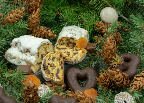 Weihnachtsstollen und verschiedene Weihnachtsleckereien auf Tannenzweigen.