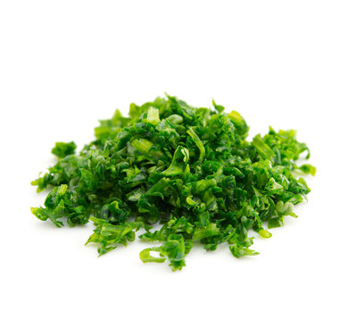 High magnification macro of a small mound of finely chopped parsley, isolated on white.