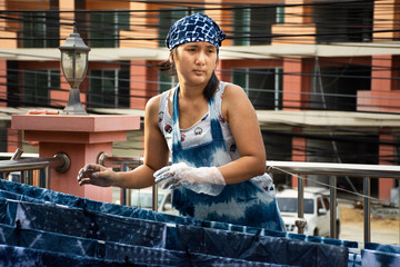 Thai women working Indigenous knowledge of thailand tie batik dyeing indigo color and hanging...