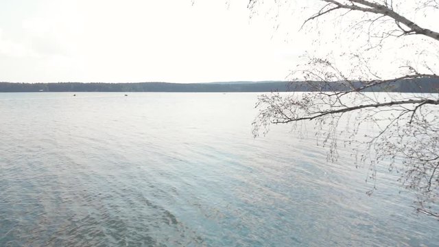 Flying back over the boat on the lake through the trees in the forest