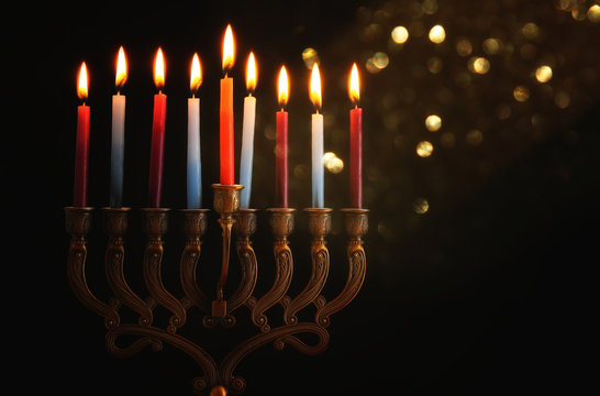 Low key Image of jewish holiday Hanukkah background with menorah (traditional candelabra) and burning candles.