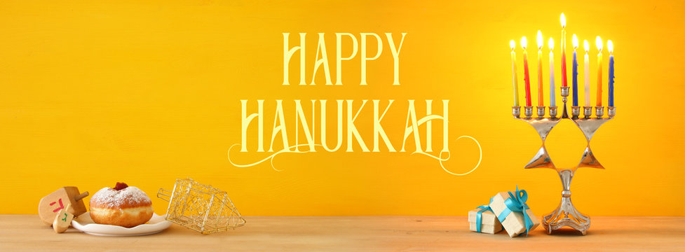 Banner of jewish holiday Hanukkah background with traditional spinnig top, menorah (traditional candelabra) and burning candles