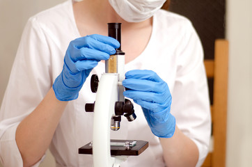 Naklejka na ściany i meble Doctor a pathologist examines under a microscope the tissue sample