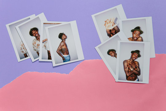 Fuji instant prints of a cool fashionable tattooed man without shirt over ripped pink and purple paper