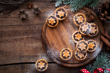 Christmas mince pies  on wooden cutting board with anise and cinnamon stick and festive xmas...