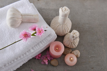 Obraz na płótnie Canvas cherry blossom sakura with,towel, candle, stones, herbal ball on gray background 