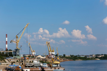 Fototapeta na wymiar Yellow harbor cranes near power station