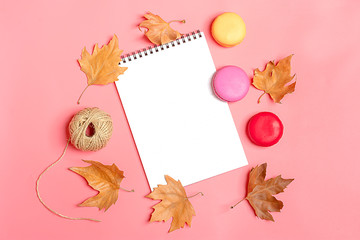 Dry maple leaves, macaroons and white notepad on yellow background Autumn concept To do list Mock up Top view Flat lay Copy space Hello September, October, November