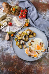 Fried eggs with croutons, sprouts, butter, cheese and a baguette with pumpkin seeds, close-up delicious breakfast concept. Vertical shot