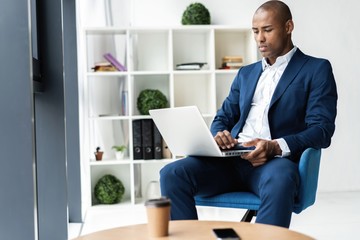 Image of african american businessman working on his laptop. Handsome young man at his desk.