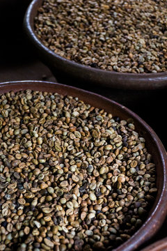 Wooden bowls of fresh coffee beans waiting to be roasted