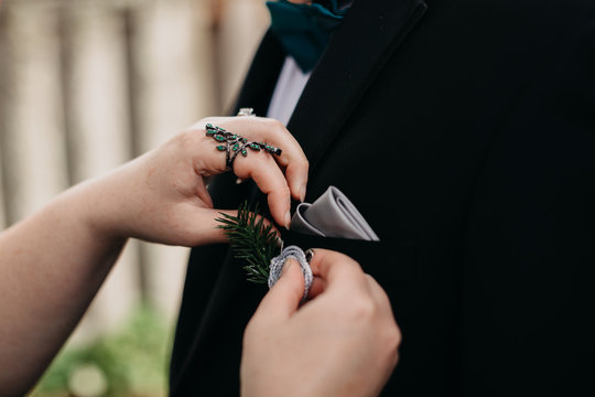 Woman Putting on Boutonniere on Groom