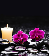 still life with two red orchid and candle on black stones 