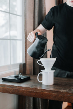 Carefully pouring water into a brewing cone