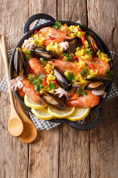 Closeup of traditional Spanish paella with seafood in a pan. Vertical top view from above