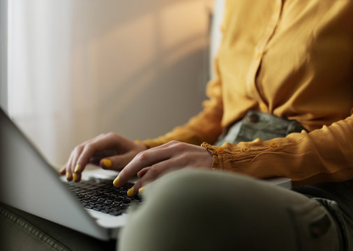 Crop woman typing on laptop