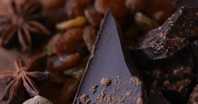 Crushed chocolate bar with raisins and anise stars. Close up, panning right