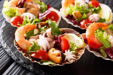 Fresh seafood salad with vegetables and lemon served in seashells close-up. horizontal © FomaA
