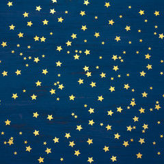 Blue Christmas wooden background with golden stars, square