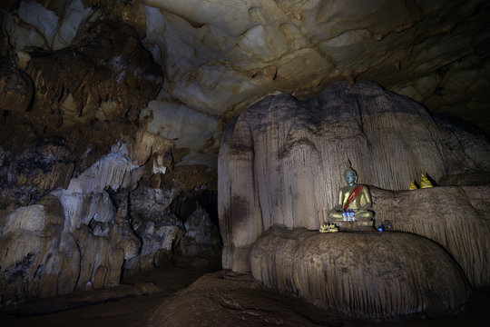 Buddha statues at the dark Tham Loup Cave near Vang Vieng, Vientiane Province, Laos.
