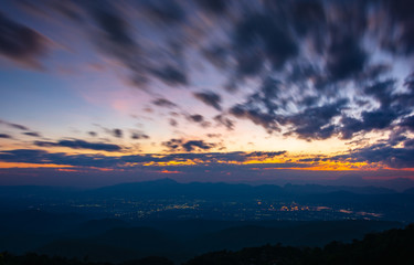 Colorfull sunset twilight sky with cloud flow over small town's light.