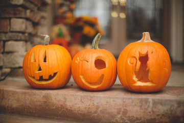 Three carved pumpkins on a doorstep
