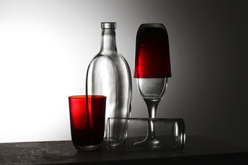 A transparent bottle and red glasses