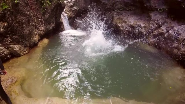 Action video of man jumping into canyon pool in the Soca valley in Slovenia.