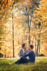 Young couple is sitting on the meadow