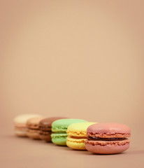 Deliious juicy makaroner, on beige color cappuccino background.