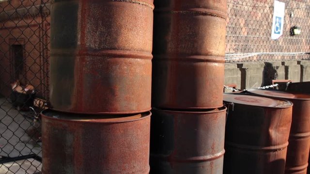 Rusty oil drums tilt up