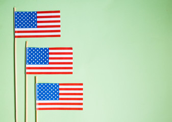 Miniature paper flag USA. American Flag on green background.