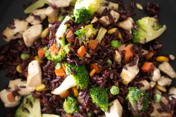 Healthy black fired rice chicken breast on hot pan.
