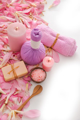 Many pink tropical petals background with and herbal ball,rolled towel,soap,candle