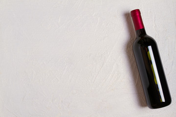 Bottle of wine on white stone texture background. View from above, top studio shot