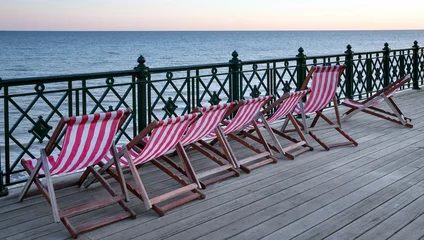 Fototapeten Hastings England. Great Brittain.. Sunset at the beach coast.  Deckchair at the pierPier © A