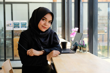 Working woman concept, Islam woman working in cafe with portrait shot on table. - Powered by Adobe