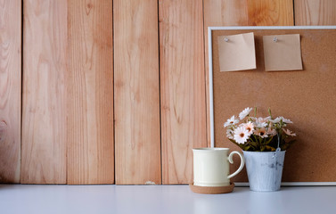 Fototapeta na wymiar Workspace with copy space coffee mug, flower, wood board and sticky note on office desk.