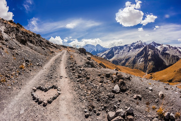 The main Caucasian ridge from mount Elbrus with a heart made of stones in the foreground