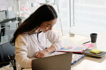 Teenage female working with laptop computer.