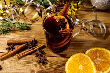 Christmas mulled wine with spices and Christmas decoration on wooden table