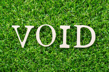 Wood letter in word void on artificial green grass background