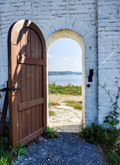 View of the Volga River through the open wooden door of the wicket of the old fortress